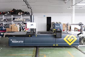 Industrial fabric cutting machine in a workshop.