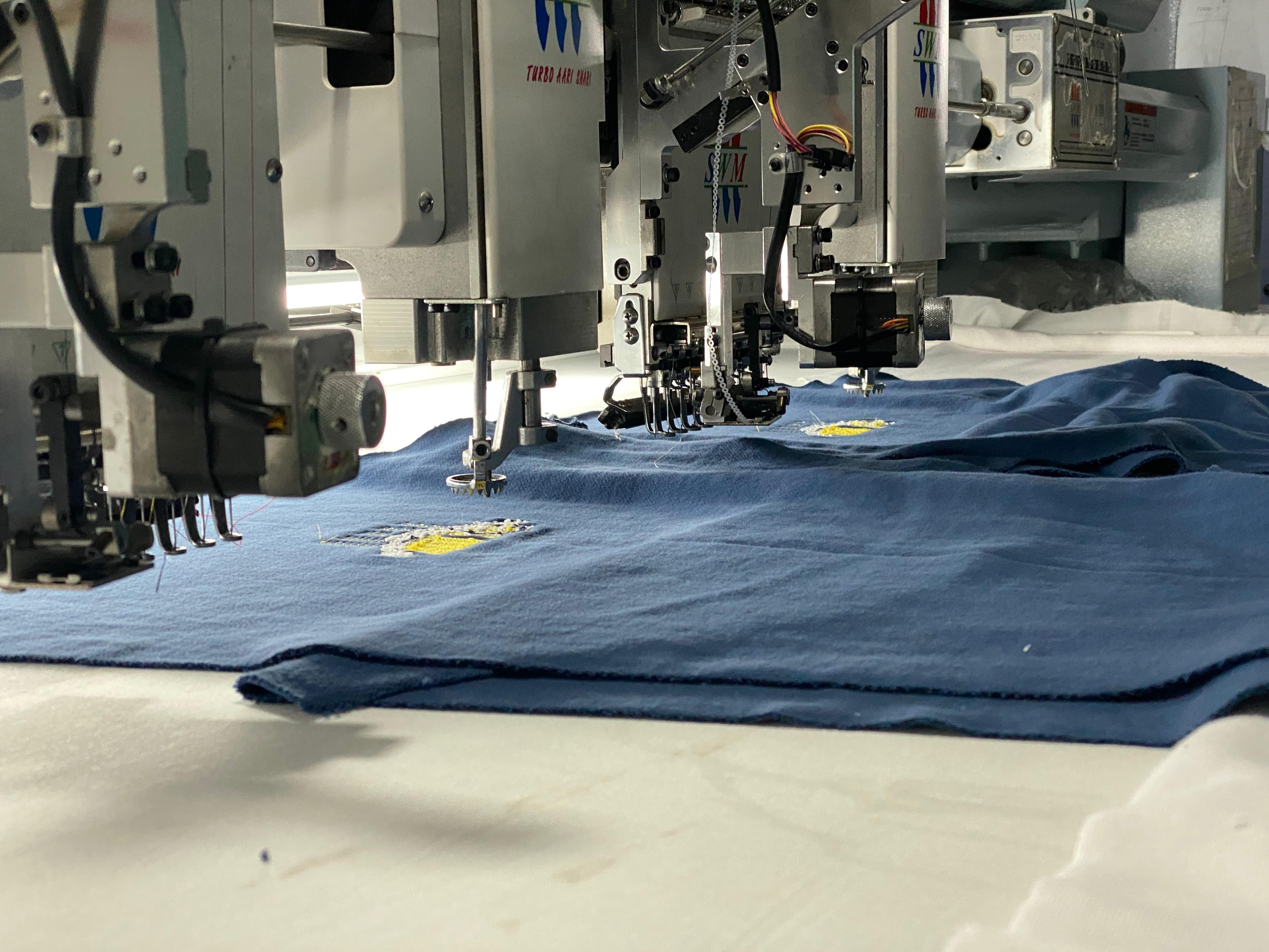 Industrial fabric cutting machine in a workshop.